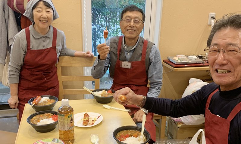 カレーを囲んで笑顔を見せるボランティアスタッフの皆さん